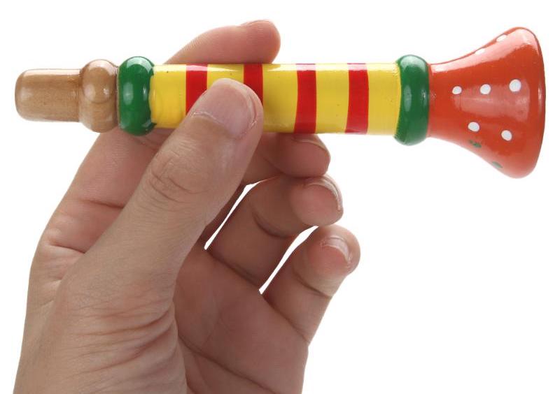 Child blowing wooden toy trumpet