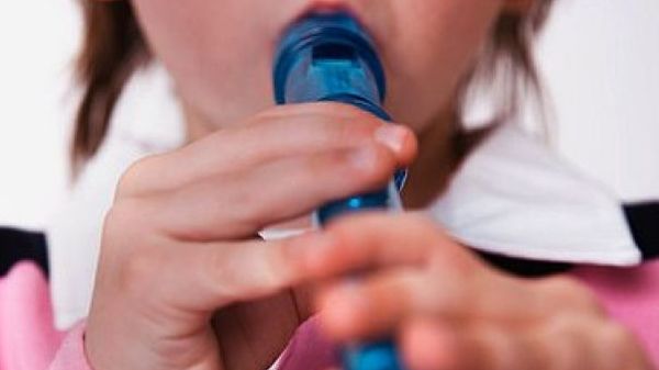 Toddler playing wooden musical flute